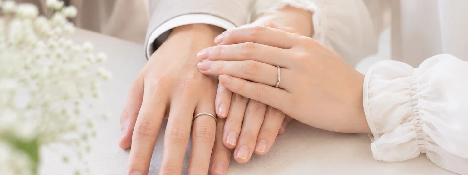 結婚指輪を着けたふたりの手元イメージ
